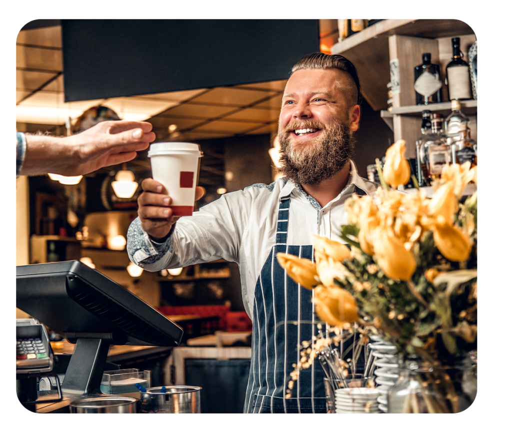 Cashier handing coffee order.