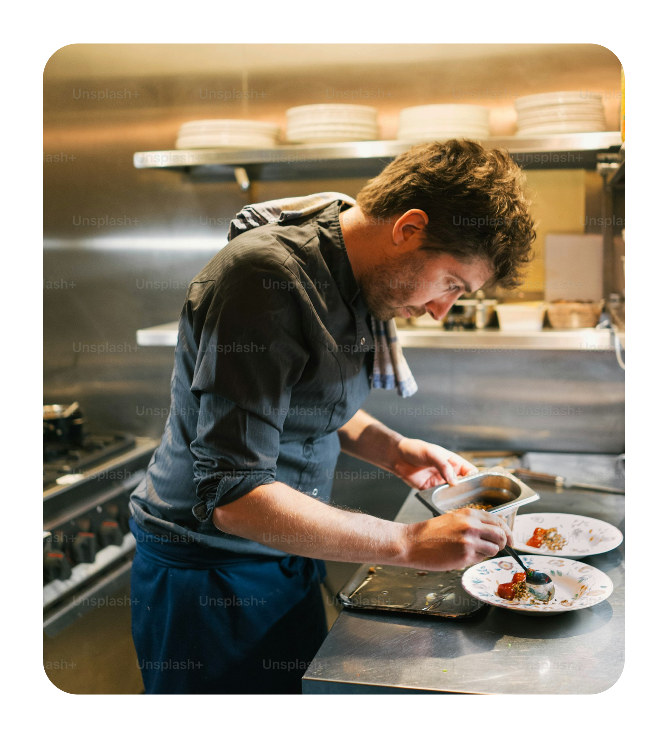 Chef plating dish in kitchen.