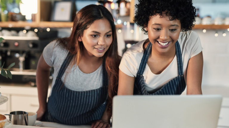 Restaurant staff reviewing hospitality technology data on a laptop