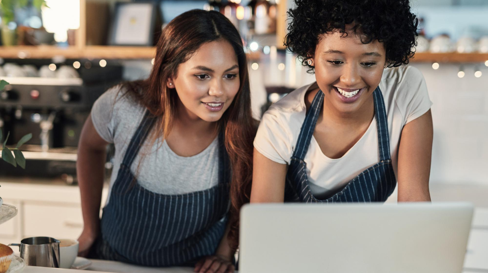 Restaurant staff reviewing hospitality technology data on a laptop