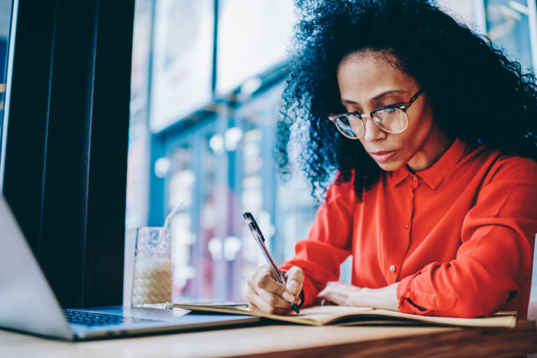 Businesswoman doing financial reporting sitting at laptop computer.