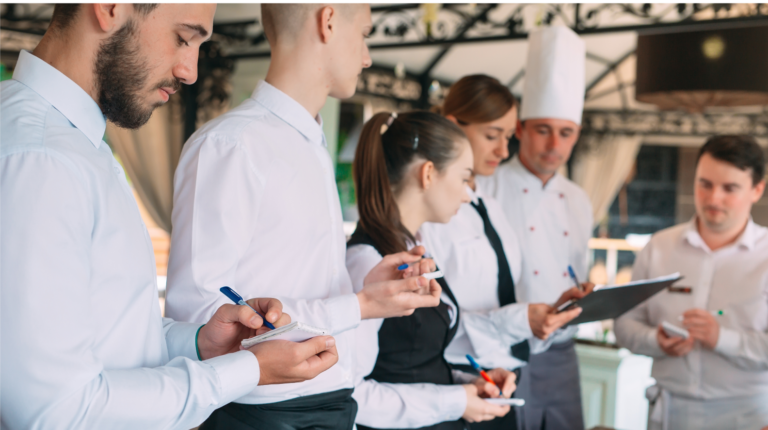 Restaurant staff reviewing notes and preparing for kitchen service